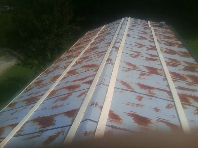 Rusted metal roof panels with new wood purlins before replacement — Storm Damage Roof Repair in Tea by Roofing Brothers