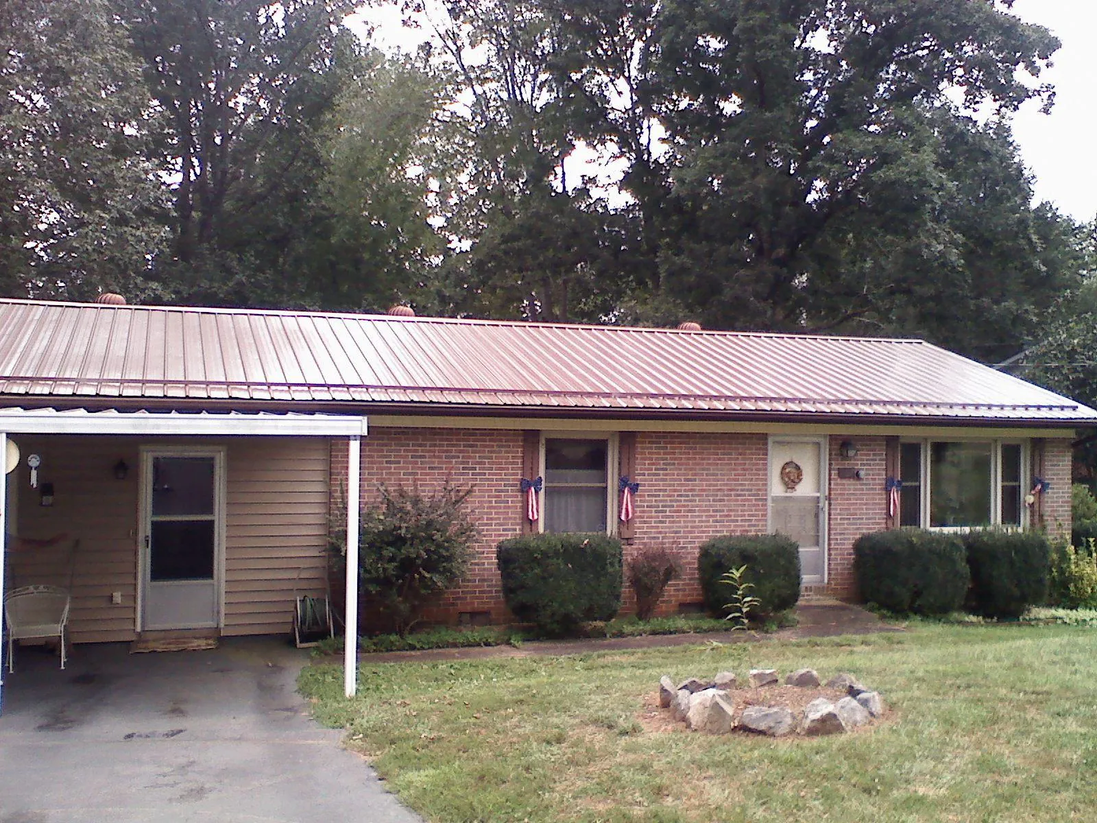 Bronze metal roof and carport on a brick ranch home — Roof Repair work by our crew in Tea